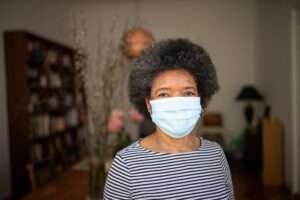 Senior Woman home quarantined with face mask