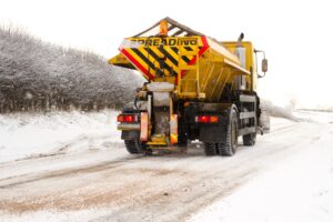 Lorry spreading grit on snowy road