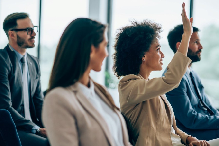 Businesswoman wants to ask a question on a seminar