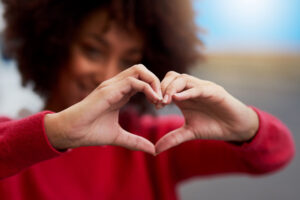 Cropped shot of a woman forming a heart shape with her fingers