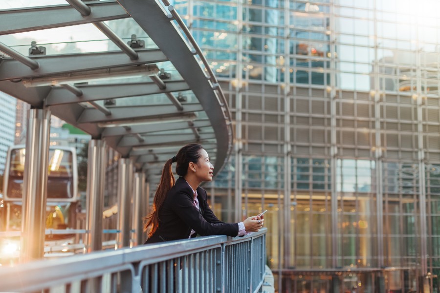 Business woman standing on pedestrian bridge in Hong Kong