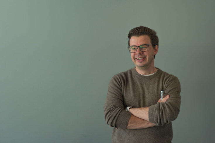 Marc Warner, founder of Faculty, smiling with his arms crossed