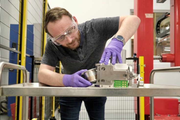 Technician Karl Myers from the University of Manchester adds a spool of fine wire to the APA winding head