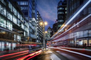 Evening view of a busy road in the City of London with traffic light trails and illuminated skyscrapers in the background