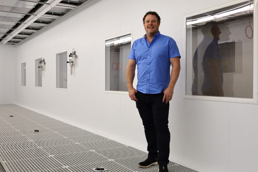 Man in a short sleeved shirt stood in a corridor