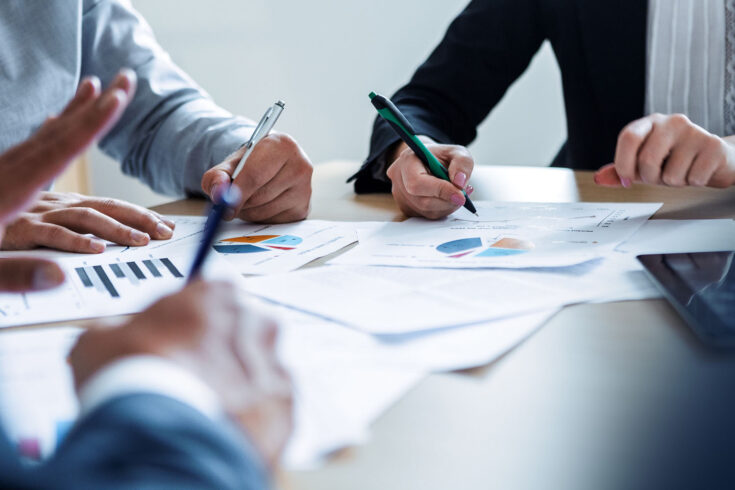 Business people teamwork with analysis cost graph on desk at meeting room.