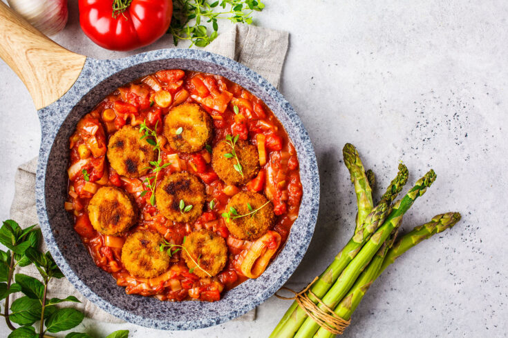 Vegetarian meatballs in tomato sauce in a frying pan. Healthy vegan food concept.