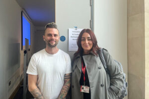 Aine and Jim, who are standing in front of a poster that promotes the ‘innovative and creative methodologies’ workshop.