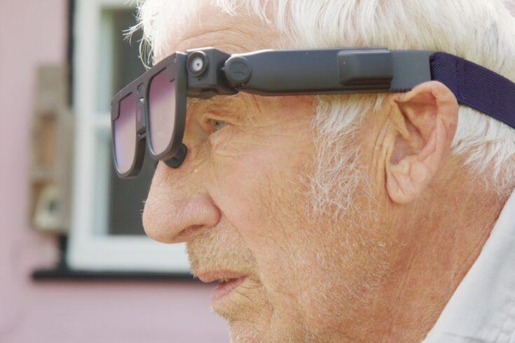 An older man wearing a pair of high-tech glasses that can help users recognise objects and people.