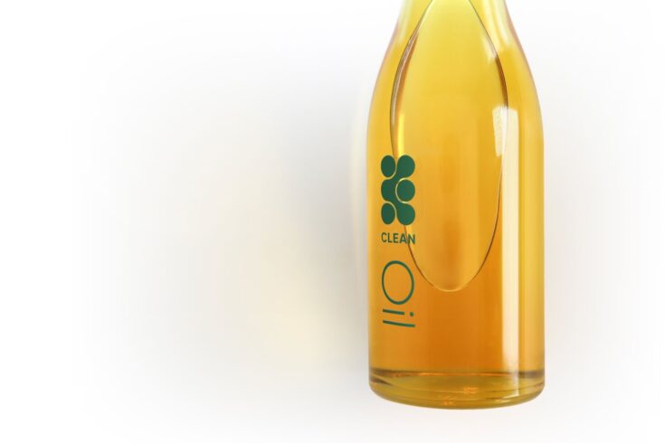 A glass bottle with oil. The glass bottle has 'CLEAN Oil' written on it.