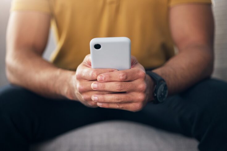 Man typing on a smartphone.