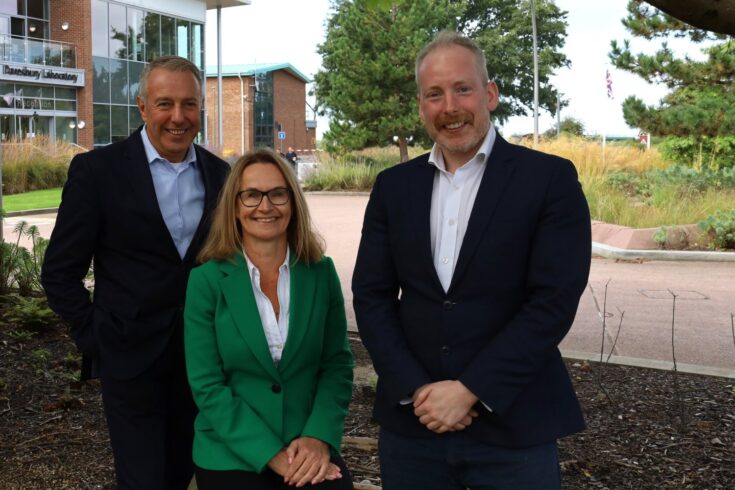 Three colleagues outside with Daresbury Laboratory in the background.