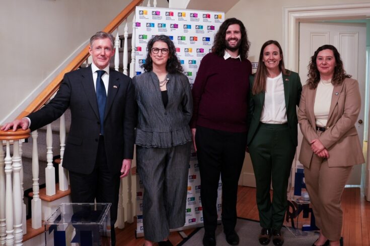 Group photo of five colleagues from UKRI North America and UKRI stood in a line in front of a staircase and a UKRI branded pull up banner. From left to right: Christopher Smith, Chloe Lianos, Tom Pospiech, Victoria Mico Egea, Sherylee Houssein