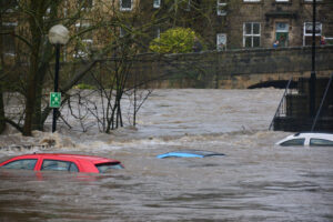 Flooding in the UK showing three cars in the water.