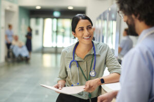 Hospital doctor chatting to male nurse in hospital foyer