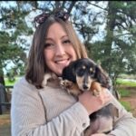 A girl smiling while holding a dog