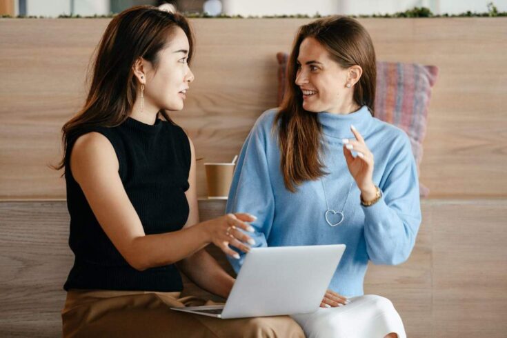 Two women talking with laptop