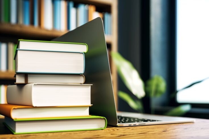 A stack of books next to a laptop